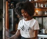 Woman wearing a white t-shirt with text in a kitchen setting
