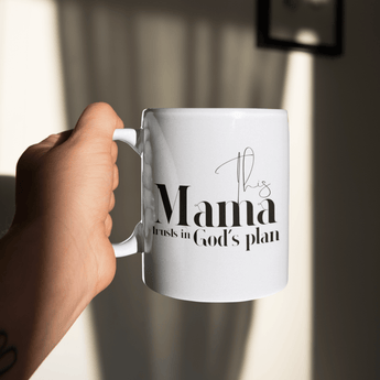 White mug with text held by a hand against a blurred background