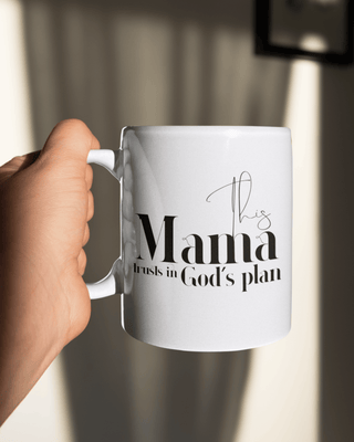 White mug with text held by a hand against a blurred background