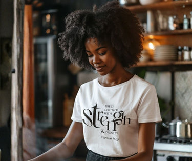 Woman wearing a white t-shirt with text in a kitchen setting