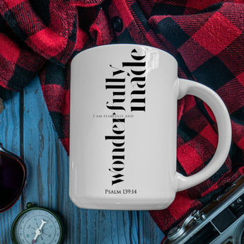 White mug with text on a red and black plaid fabric background